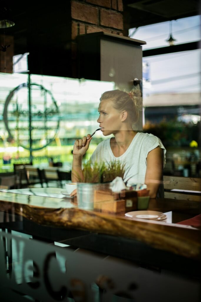 Reflective moment of a woman savoring food in a Phuket café. Perfect concept of relaxation and cafes.